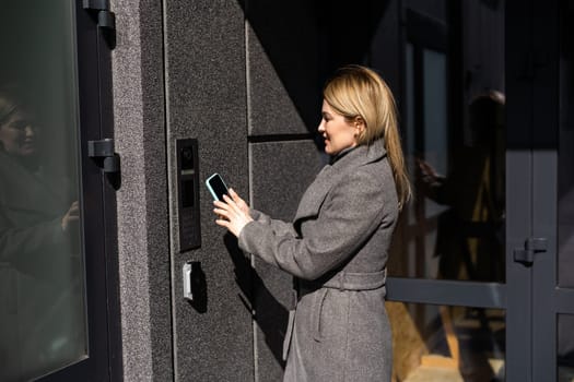 Smart home concept - close up of woman use mobile phone to open electronic lock.