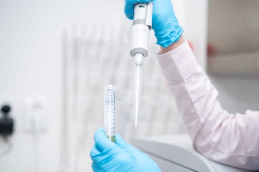 Scientist collects the sample using automatic pipette. Chemical and clinic analysis concept.
