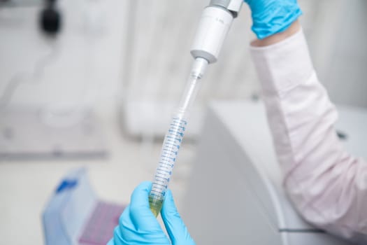 Scientist collects the sample using automatic pipette. Chemical and clinic analysis concept.