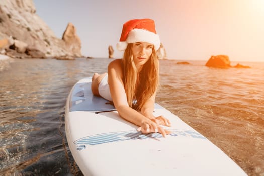 Close up shot of happy young caucasian woman looking at camera and smiling. Cute woman portrait in bikini posing on a volcanic rock high above the sea