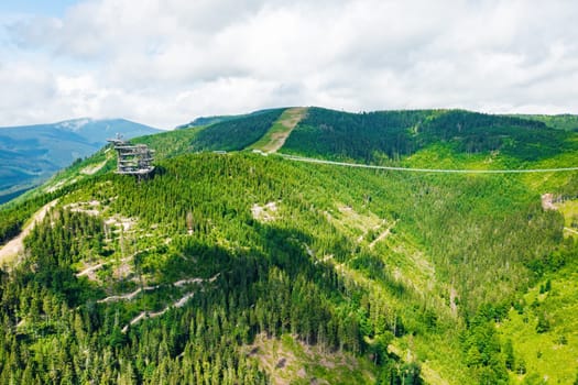 Aerial view of the worlds longest 721 meter suspension footbridge Sky bridge and observation tower the Sky walk in the forest, between mountains, Dolni Morava Ski Resort, Czech Republic.