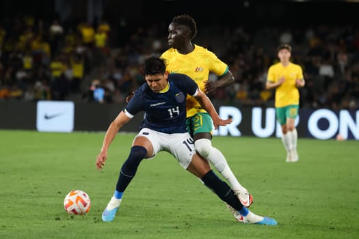 MELBOURNE, AUSTRALIA - MARCH 28: Garang Kuol of Australia battles with Xavier Arreaga of Ecuador during an international friendly match between the Australia Socceroos and Ecuador at Marvel Stadium on March 28, 2023 in Melbourne, Australia.