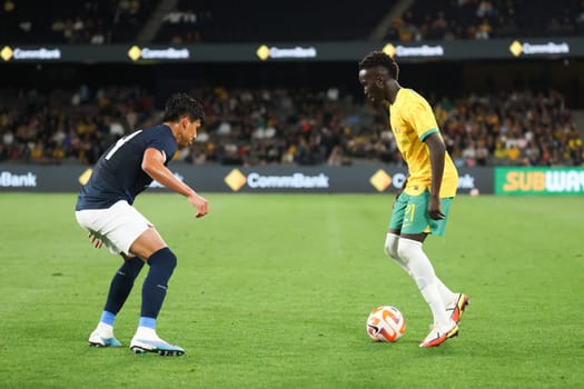 MELBOURNE, AUSTRALIA - MARCH 28: Garang Kuol of Australia battles with Jose Cifuentes of Ecuador during an international friendly match between the Australia Socceroos and Ecuador at Marvel Stadium on March 28, 2023 in Melbourne, Australia.