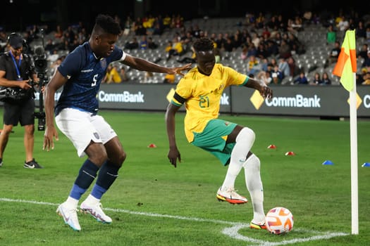 MELBOURNE, AUSTRALIA - MARCH 28: Garang Kuol of Australia battles with Jose Cifuentes of Ecuador during an international friendly match between the Australia Socceroos and Ecuador at Marvel Stadium on March 28, 2023 in Melbourne, Australia.
