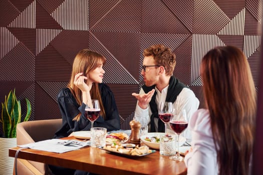 Having conversation. Indoors of new modern luxury restaurant.