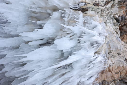 White ice hangs in long drops in a cave on Lake Baikal