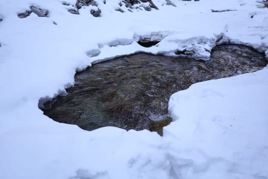 Thawed place on the mountain river you can see rocks and strong water flow Arshan Buryatia village