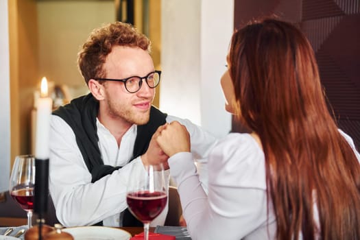 Couple of young guy and adult woman. Indoors of new modern luxury restaurant.