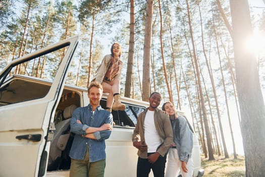 Destination place. Group of young people is traveling together in the forest at daytime.