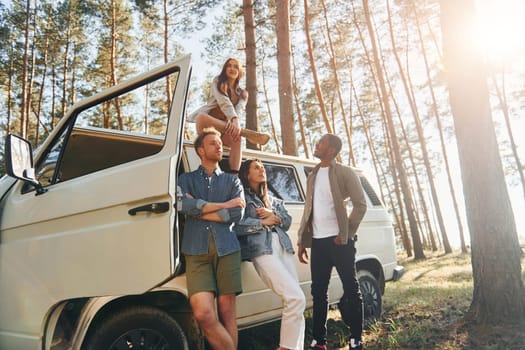 Destination place. Group of young people is traveling together in the forest at daytime.