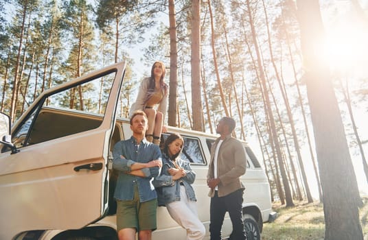 Destination place. Group of young people is traveling together in the forest at daytime.