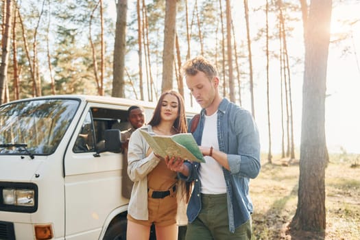 Group of young people is traveling together in the forest at daytime.