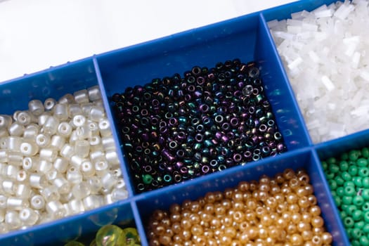 Colorful beads in containers close up, handicrafts, macrophoto