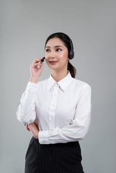 Attractive asian female call center operator with happy smile face advertises job opportunity on empty space, wearing a formal suit and headset on customizable isolated background. Enthusiastic