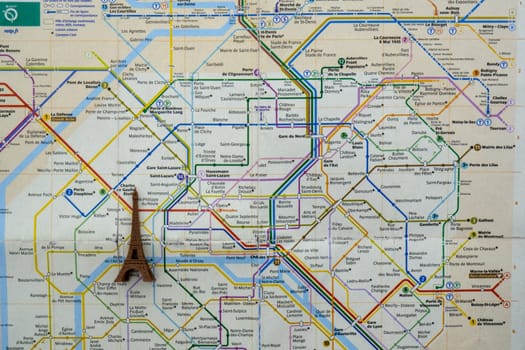 Close up of Paris metro subway map with a toy Eiffel tower on top. High quality photo