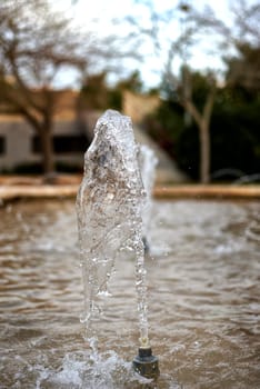 A jet of water from a fountain on an out-of-focus background.Fast shutter speed, transparent, empty, clear, free space, front view