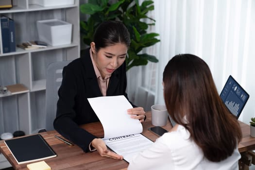 Business deal meeting, young businesswomen carefully reviewing terms and condition of contract agreement papers in office. Corporate lawyer give consultation on contract deal. Enthusiastic