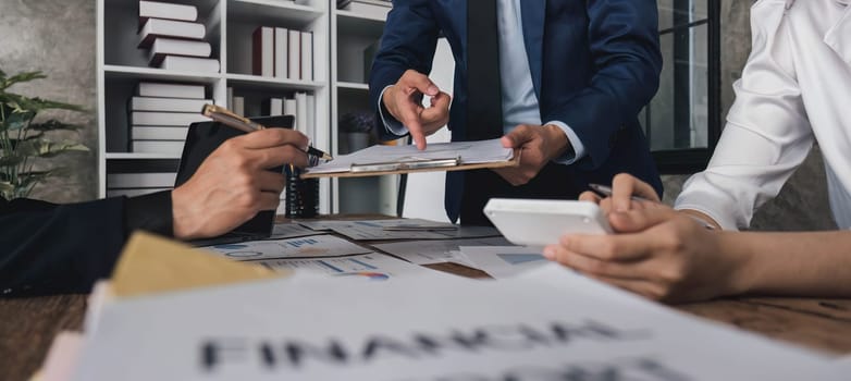 Business People Meeting using laptop computer,calculator,notebook,stock market chart paper for analysis Plans to improve quality next month. Conference Discussion Corporate Concept....