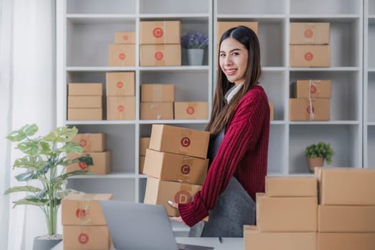Startup small business entrepreneur SME, asian woman packing cloth in box. Portrait young Asian small business owner home office, online sell marketing delivery, SME e-commerce telemarketing concept...