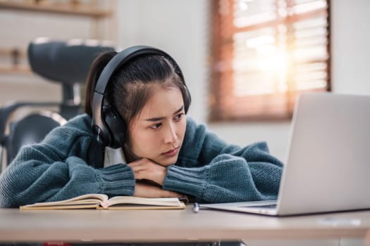 Bored young asian girl student studying, looking upset at laptop screen, attend boring online classes or lecture. Tired bored lazy..