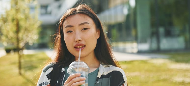 Portrait of young asian woman that is outdoors at daytime.