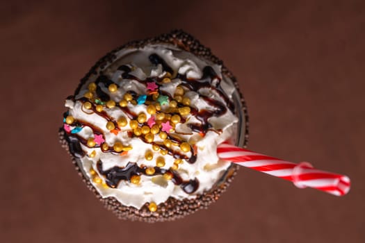 top view of a milkshake with multicolored sprinkles and a straw.