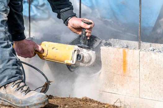 cutting concrete bricks with an electric grinder.