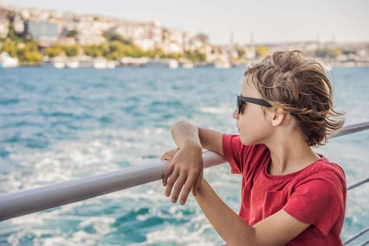Happy boy enjoying the sea from ferry boat crossing Bosphorus in Istanbul. Summer trip to Istanbul. Traveling with kids concept.