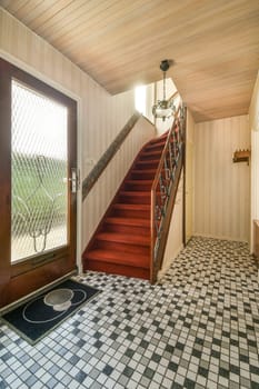 a room with stairs and tiled floor in the middle part of the room is an open door that leads to another room