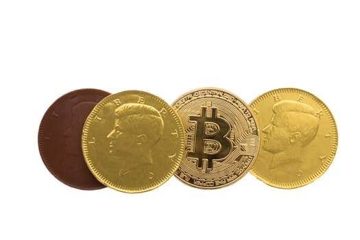 Arrangement of candy chocolate coins in gold foil and a bitcoin on a white background