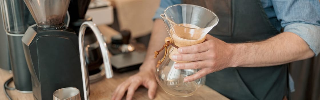 Close up of barista hands holds in his hands a glass vessel for making filter coffee.