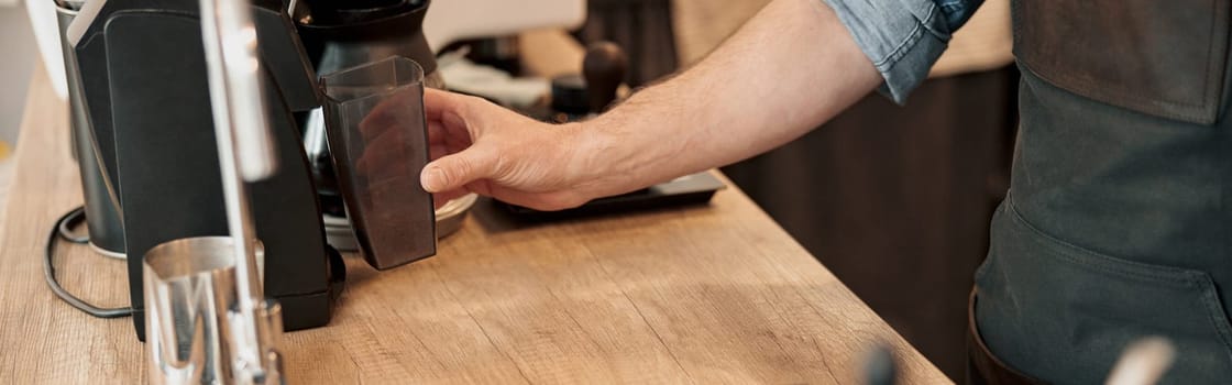 Close up of barista hand installs a container with coffee beans in the coffee machine