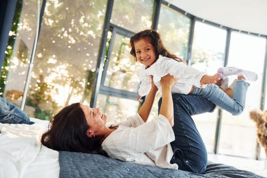 Playing together. Mother and her daughter spending time at home.