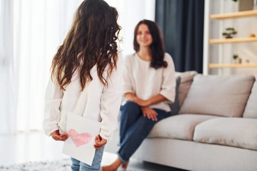 Surprise for mother. Woman and her daughter spending time together at home.