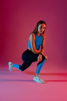 Sporty woman stretching her legs in studio before sports training or workout. High quality photo