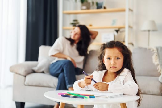 Modern design. Mother and her daughter spending time together at home.