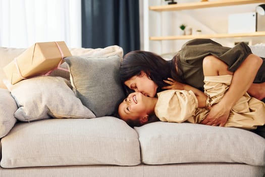 Lying down on the bed. Mother and her daughter spending time together at home.