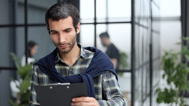 Young businessman working with documents looking through papers in folder