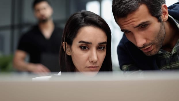 businesswoman talking to her colleague about business plan in conference while sitting behind her laptop at office.