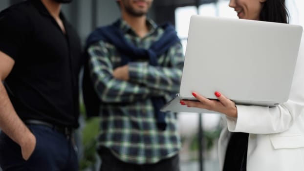 Businessmen in the lobby of the office present a laptop. business concept