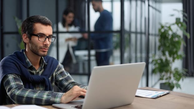 business man in glasses and casual clothes working on laptop in modern office
