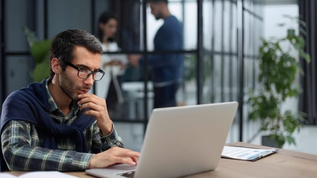 business man working on laptop in modern office.