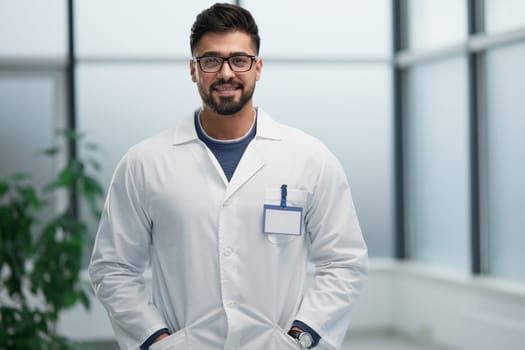 portrait of a male doctor standing in the lobby and looking ahead