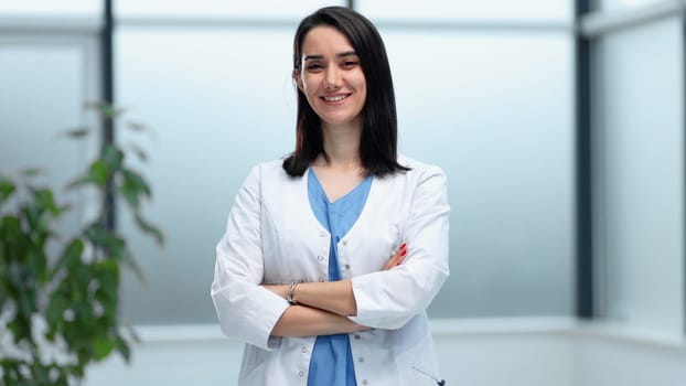 female doctor in hospital corridor with arms folded, portrait