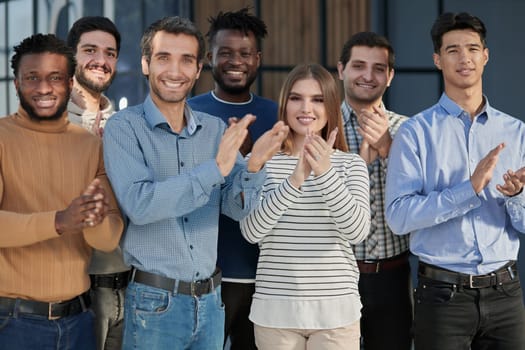 Human resources. Group portrait of smiling employees of a friendly team of different racial genders standing together in an office.