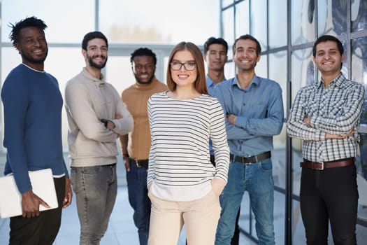 Confident in your team. Attractive young business people smiling while standing in a row with other people