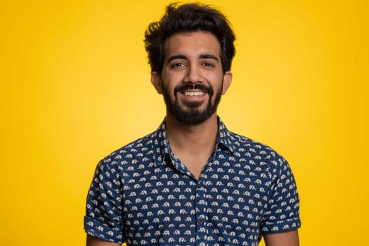 Portrait of happy calm indian man smiling friendly, glad expression looking away dreaming resting, relaxation feel satisfied concept good news, celebrate win. Hindu guy on studio yellow background