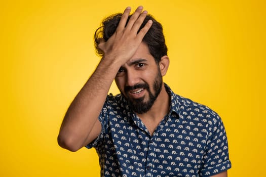 Bearded indian man feeling hopelessness loneliness, nervous breakdown, loses becoming surprised by lottery results, bad fortune loss, unlucky news. Hindu young guy isolated on studio yellow background