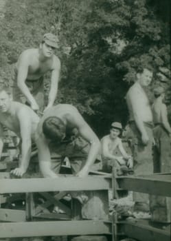 THE CZECHOSLOVAK SOCIALIST REPUBLIC - CIRCA 1970s: Retro photo shows combat engineers - sappers build the bridge construction. Vintage photography. Circa 1970.