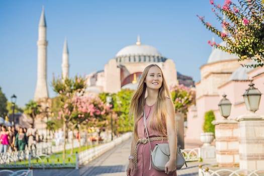 Woman enjoy beautiful view on Hagia Sophia Cathedral, famous islamic Landmark mosque, Travel to Istanbul, Turkey. Sunny day architecture and Hagia Sophia Museum, in Eminonu, istanbul, Turkey. Turkiye.
